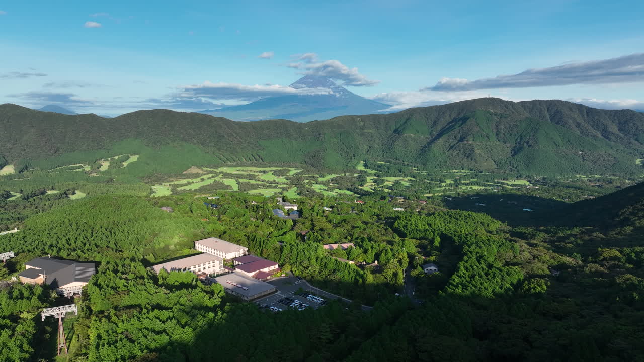 Serene View Of Mount Fuji From Hotel In Hakone, Japan, Overlooking Lush Green Forests And Valleys In Daylight. wide aerial shot