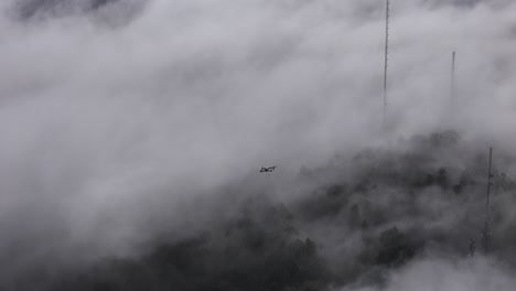 drone flying above the low clouds that were rolling on the mountains of portugal