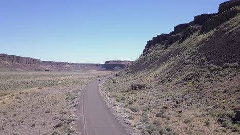 Aerial-follows-van-driving-along-bottom-of-Frenchman-Coulee,-WA-state