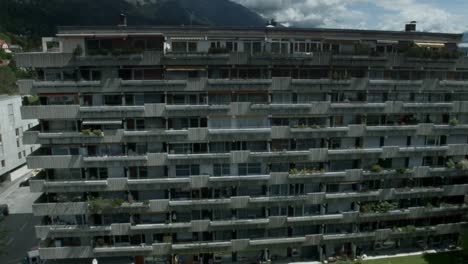 Shot-of-a-concrete-apartement-tower-with-balconies-with-clouds-in-the-background