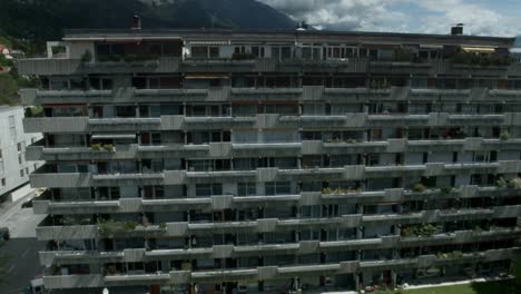 shot of a concrete apartement tower with balconies with clouds in the background