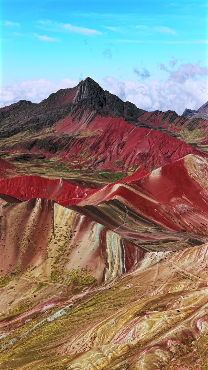 Rainbow Mountain Vinicunca Montaña de Siete Colores Perù Perù ripresa aerea verticale con drone bobina parallasse Ande peruviane ghiacciaio sciolto Vilcanota Regione di Cusco cielo azzurro mattutino nuvole stagione delle piogge in avanti