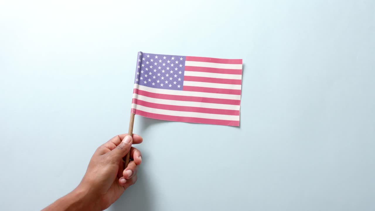 Close up of hand holding national flag of usa on white background