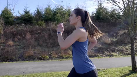 Young-woman-out-running-winter-slow-motion-tracking-shot