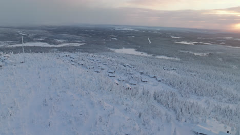 Vista-Aérea-Alrededor-De-Una-Ciudad-Cabaña-En-La-Cima-De-Una-Caída-Iso-syote,-Amanecer-En-Finlandia