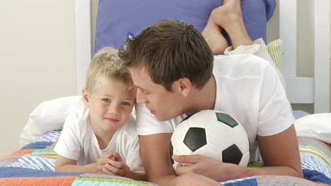 father and son playing with a ball in bedroom