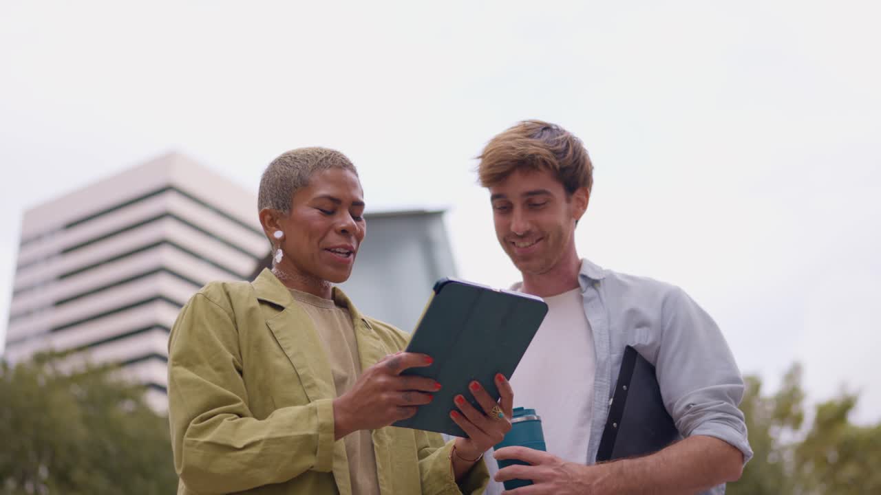 People looking at tablet outdoors