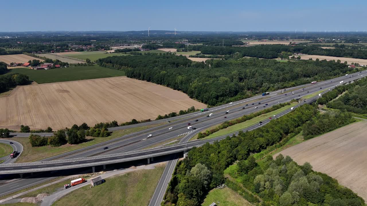 Traffic on multi-Land highway in American suburb. Rural landscape during sunny days with blue sky. Aerial forward wide shot. Cars and vehicles on expressway in Wisconsin
