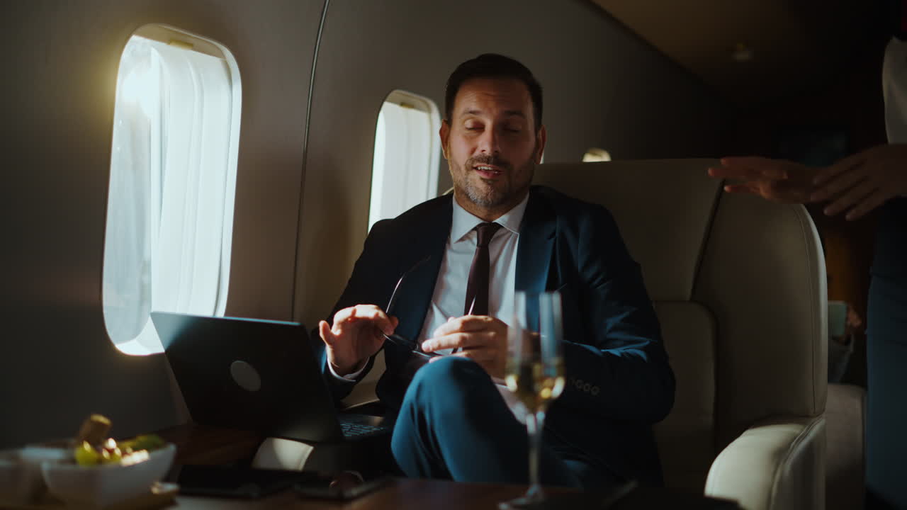 Uomo d'affari che lavora su un jet privato con assistente di volo