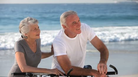 pareja de edad con bicicletas mirando la playa