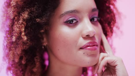 Biracial-woman-with-dark-hair-in-pink-light,-slow-motion