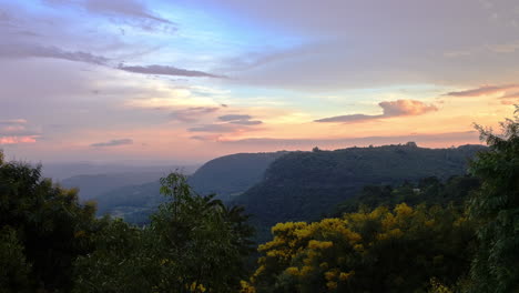 Wonderful-and-intensive-sunset-of-bold-colors,-over-a-misty-and-foggy-valley,-distant-mountains