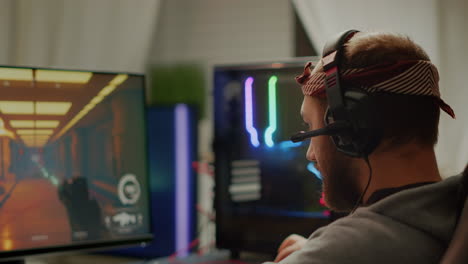 focused man gamer putting headset playing shooter online video game