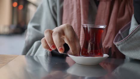 mujer bebiendo té turco en una cafetería