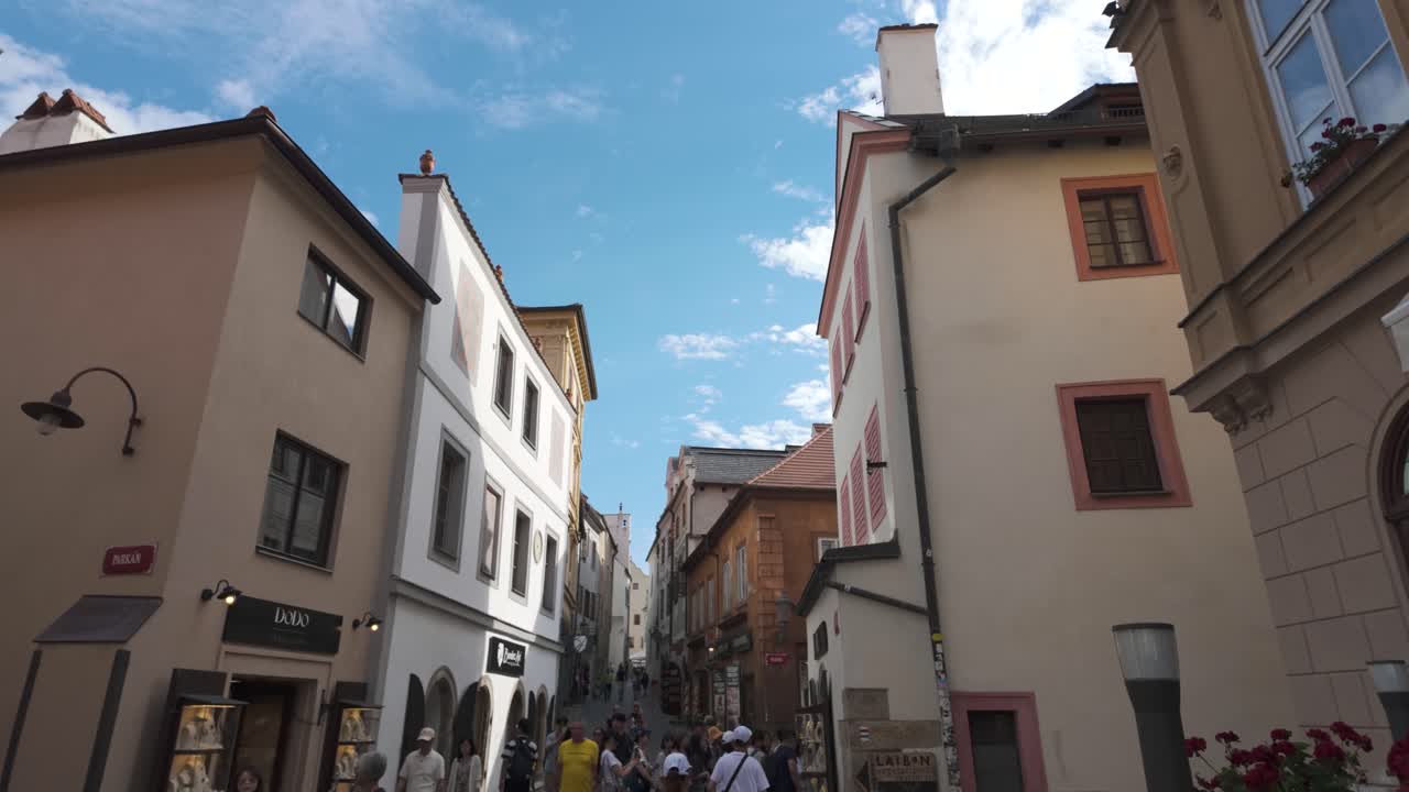Charming narrow street with colorful historic buildings under a bright blue sky in Český Krumlov
