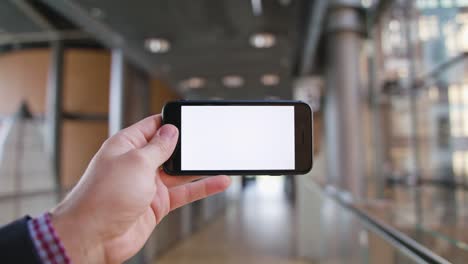 una mano sosteniendo un teléfono con una pantalla blanca