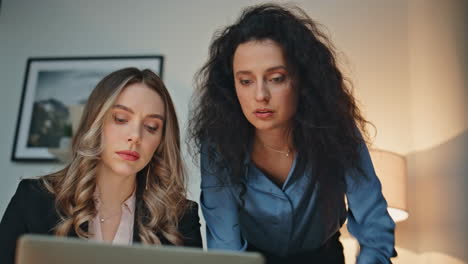 Business professionals solving problem pointing laptop. Closeup women discussing