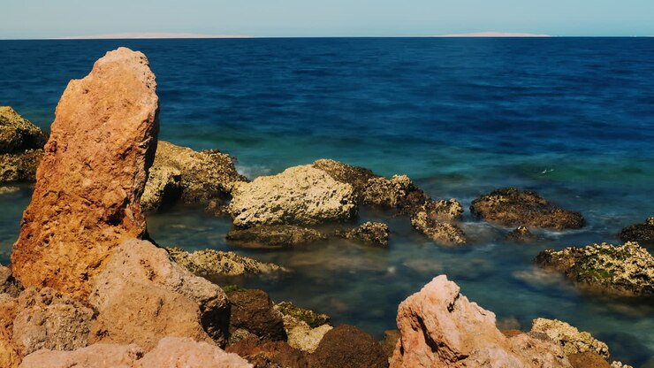 Surf At The Rocks - Red Stone On A Background Of Blue Sea 4k Timelapse Video