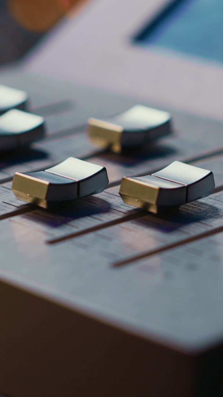 Adjusting Faders on a Professional Audio Mixing Console