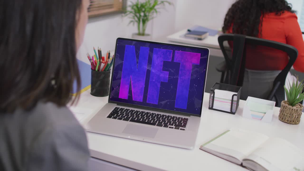 video de una mujer caucásica trabajando en una computadora portátil con nft en la pantalla
