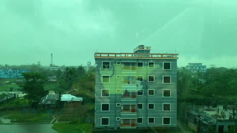 películas de teléfonos inteligentes gotas de lluvia en la ventana durante el monzón, capturando los reflejos dentro del apartamento