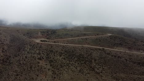 Un-Gran-Circuito-En-Zigzag-Conduce-A-Un-Camino-De-Grava-Que-Sale-De-Una-Meseta-Ondulada-Y-Brumosa