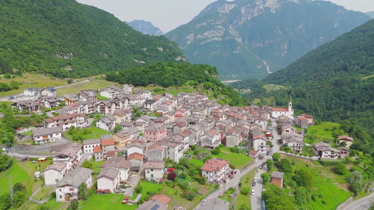 Il drone cattura il fascino di Igne, immersa nelle Dolomiti, circondata da cime montuose mozzafiato e paesaggi lussureggianti.