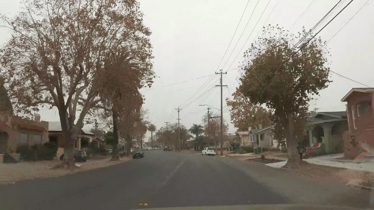 A short drive in time lapse across a busy neighborhood on a foggy day.
