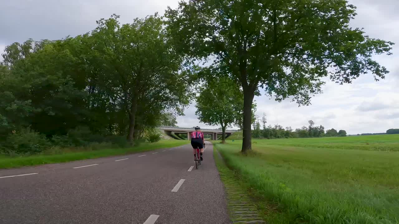 POV Drive on a Road Through Green Countryside with a Cyclist