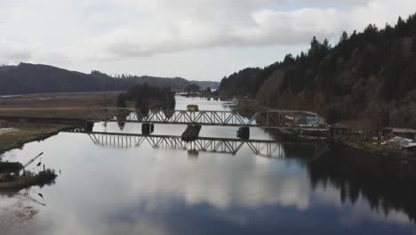 vintage arched railbridge over large siuslaw river on cushman town, oregon