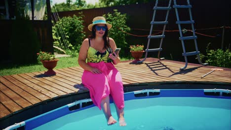 woman in pink pants and hat relaxing by the poolside, enjoying summer leisure time outdoors