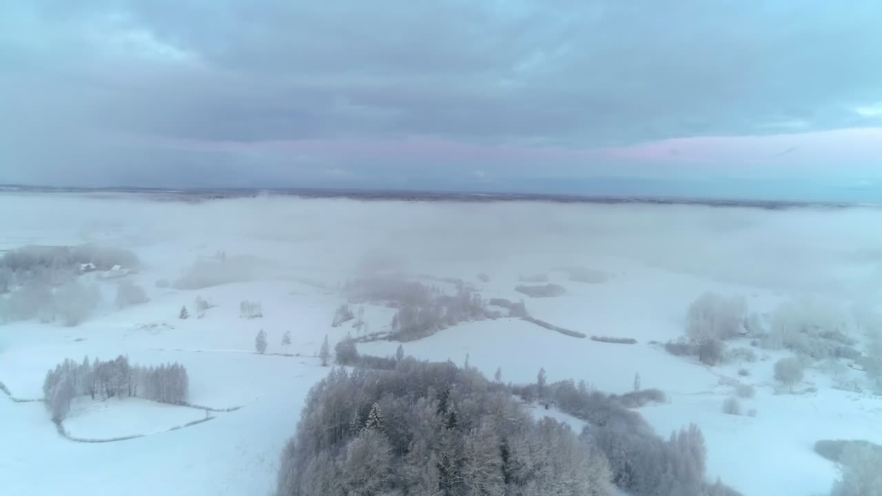 Sumua leijailemassa lumipeitteisen maiseman yllä heti auringonlaskun jälkeen.