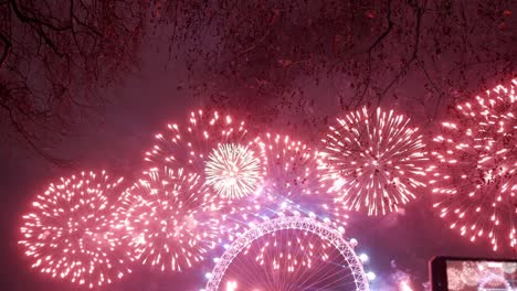 a view of the london eye lit up at night with colorful fireworks celebrating the sky