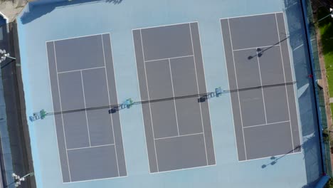 three blue hard tennis courts from above, aerial shot