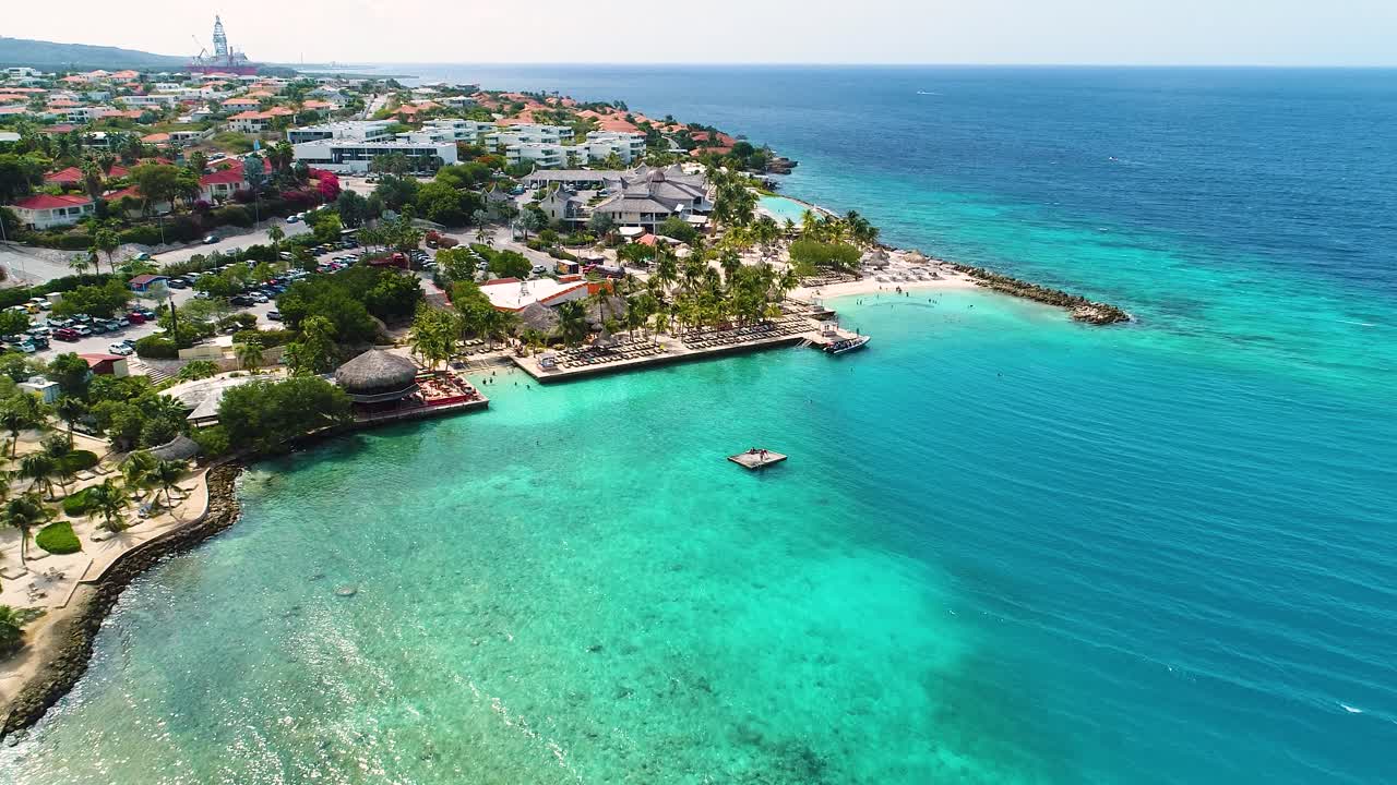 Badgäster hoppar från flytbrygga vid Zanzibar-stranden, Jan Thiel, Curacao, njuter av semester i Karibien, drönaröversikt