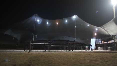 empty army tent lighted at night with litght bulbs