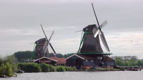 two dutch windmills on the bank of the canal