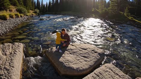 father and child enjoying nature by a river