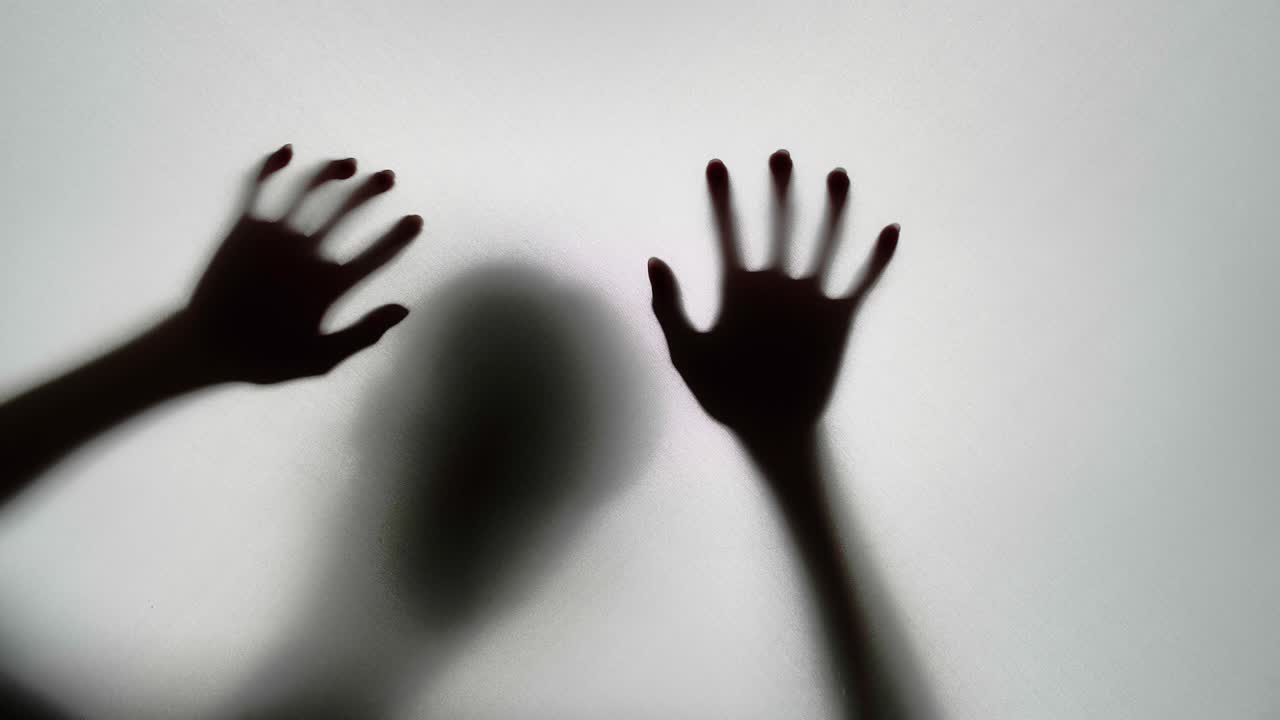 Hands reaching through a window's shadow