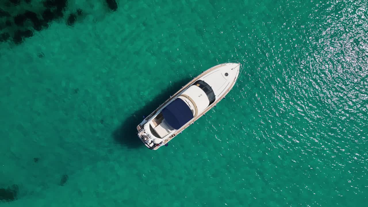 Ripresa con drone dall'alto di una barca all'ancora su acqua cristallina