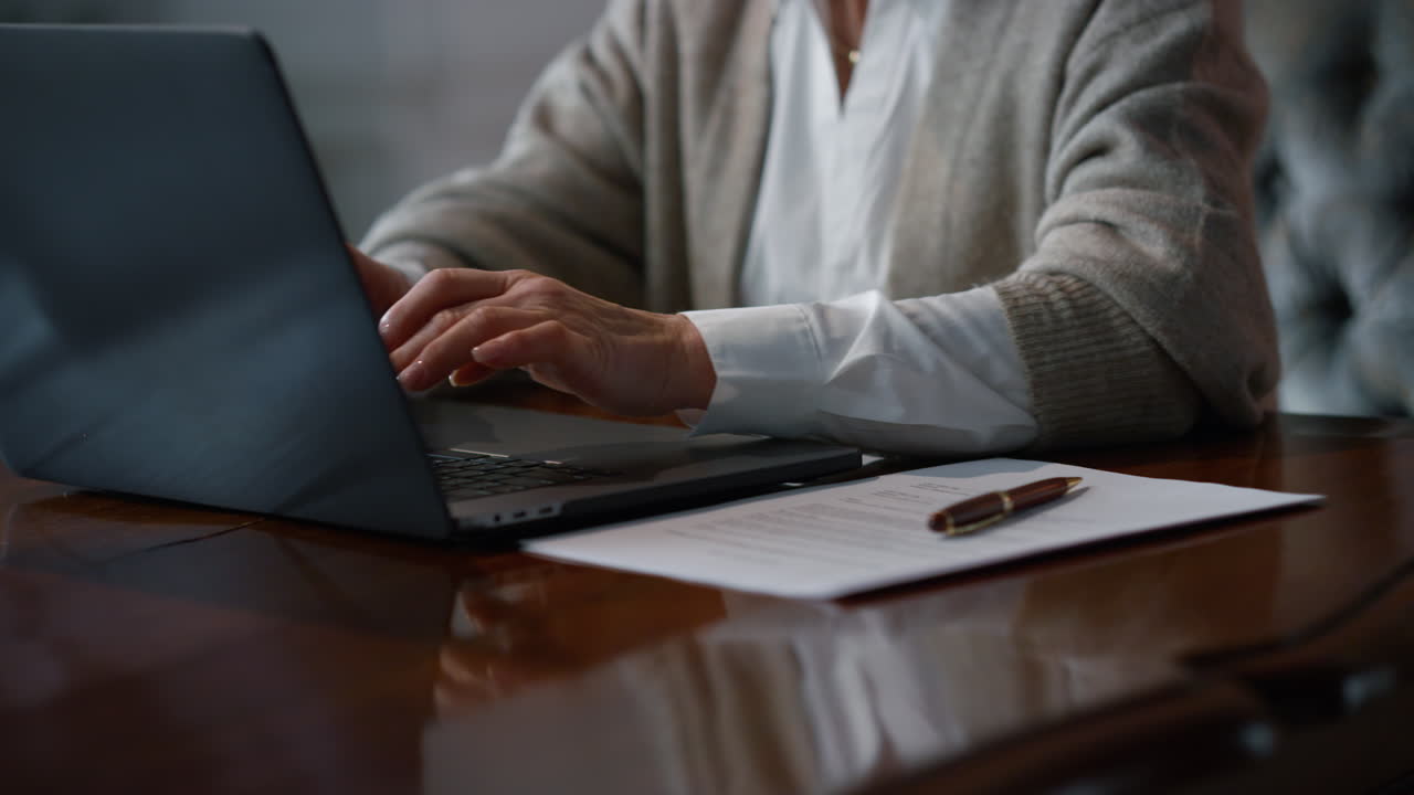 Senior woman hands typing laptop at luxury interior