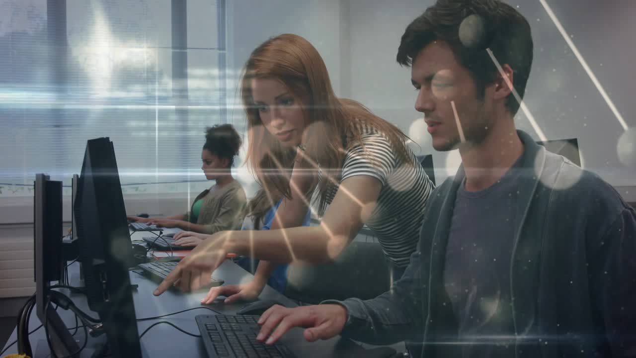 Peer tutor in computer lab tapping keyboard and causing data overlay across monitors guiding man