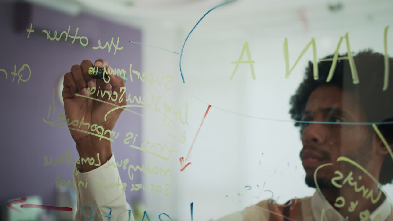 Marketer Analyzing Campaign when Writing Business Ideas on Transparent Wall