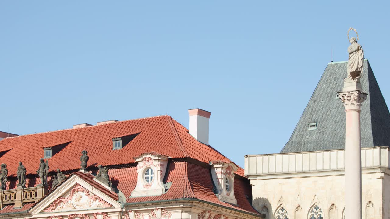Baroque architecture, statues, and a monument under clear blue sky in Prague, Czech Republic