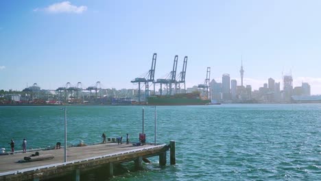Slowmo---Panning-Shot-Devonport-Pier-Mit-Angelern,-Auckland-Hafen-Und-Skyline-Im-Hintergrund,-Neuseeland