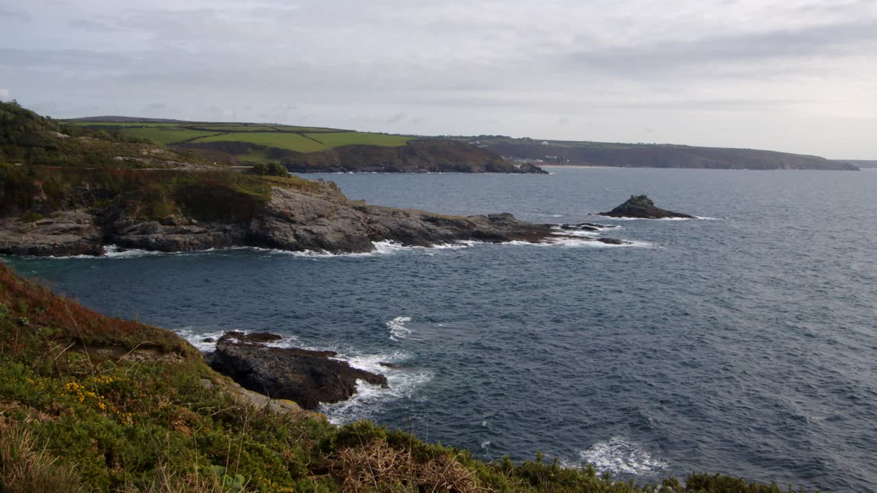 wide shot of Bessy's Cove,The Enys headland with Praa Sands in the background