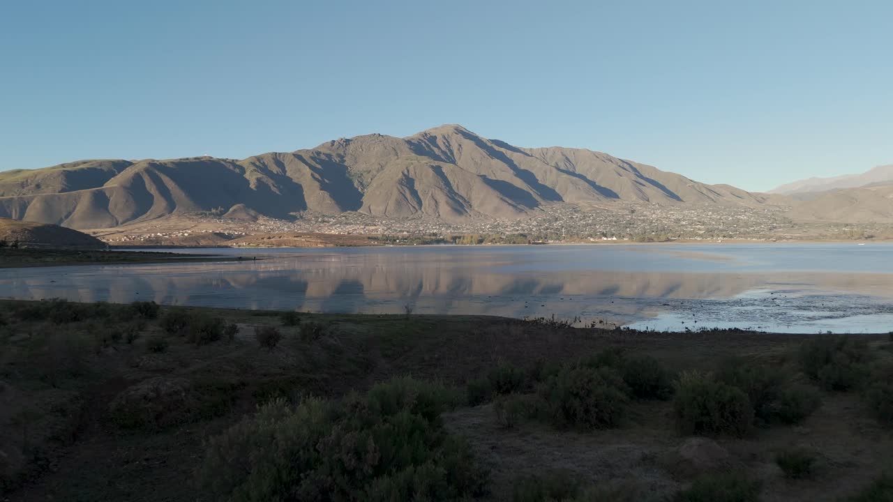 empuje aéreo hacia el agua sobre el paisaje desértico con montañas más allá del agua en la distancia