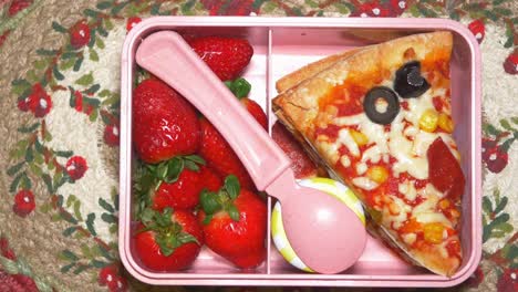 una linda caja de almuerzo de pizza y fresa