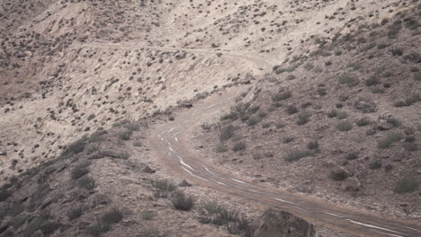 a winding dirt road through a desert landscape