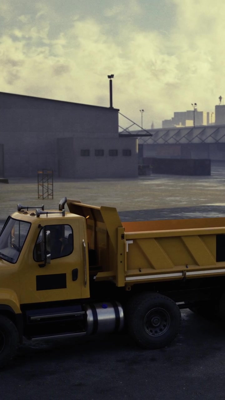 Yellow dump truck parked at an industrial site during overcast day